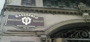 Η πινακίδα του εστιατορίου "Hazzopulo", τίτλος προφανώς προερχόμενος από το περίφημο "Πασάζ Χατζόπουλο" (Στοά Χατζόπουλου) που υπάρχει στο Π�ραν